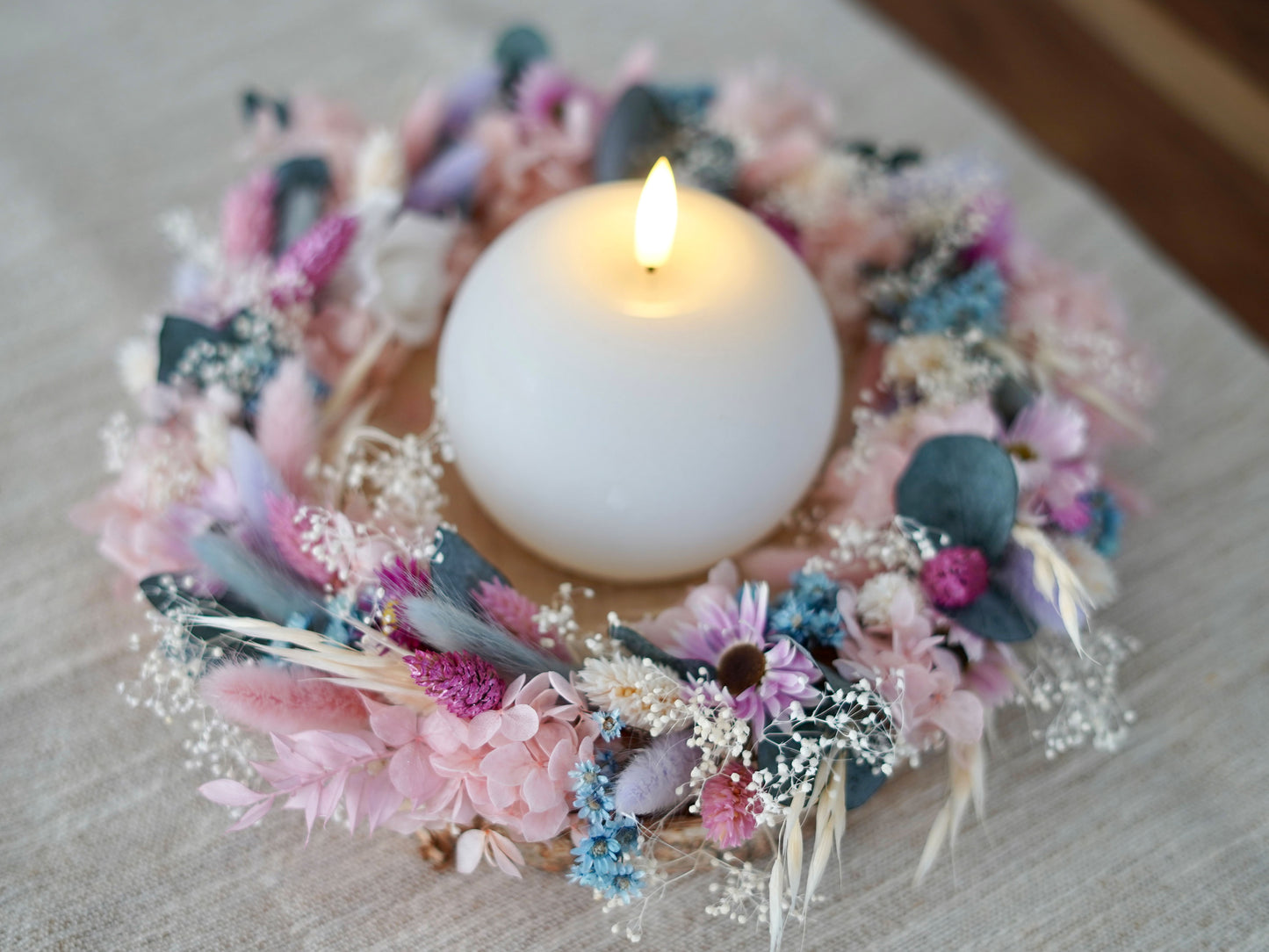 Tischdekoration: handgefertigte Trockenblumenkranz mit zarten Blüten in rosa, eisblau, lila/flieder und weiß, ergänzt durch konservierten Eukalyptus und Schleierkraut. Mit LED Kerze