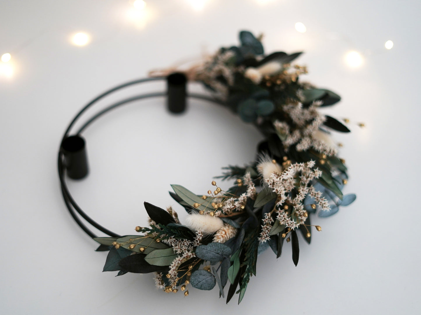 Adventskranz gebunden an einen schwarzen Metallkranz aus Trockenblumen, konserviertem Eukalyptus, Olivenzweigen und Tanne "Thuja"