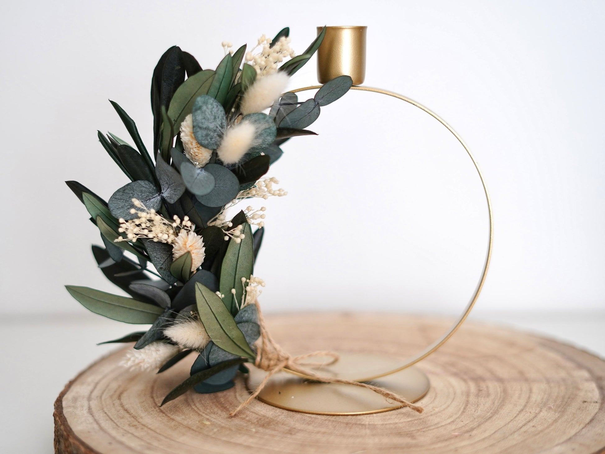 Ringförmiger Stabkerzenhalter aus Metall in Gold, dekoriert mit konserviertem Eukalyptus, Olivenzweigen sowie Lagurus und Phalaris.