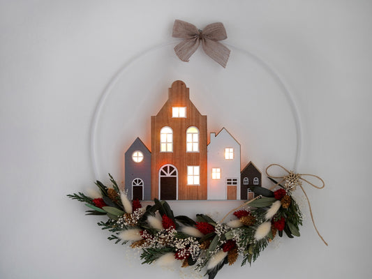 Weihnachtsdekoration Trockenblumenkranz gebunden an einen Metallring aus Trockenblumen, haltbar gemachte Olivenzweige und Tannengrün. Mit leuchtenden Häuschen. Farben: rot, grün, gold weiß