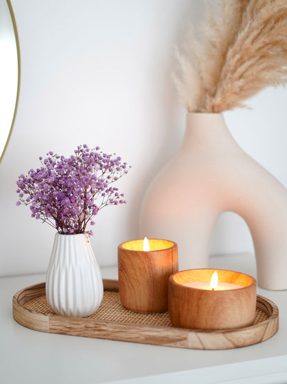 Trockenblumenstrauß konserviertes Schleierkraut lila mit weißer Kramikvase auf einem Dekotablett aus Rattan und Holz. Dazu stehen LED Kerzen