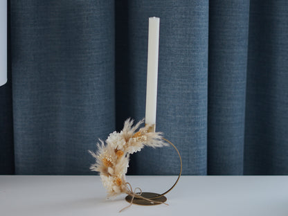 Goldener Kerzenhalter in Ringform mit Trockenblumen, dekoriert mit Pampasgras und Hortensie, als festliche Tischdeko im weihnachtlichen Wohnzimmer.